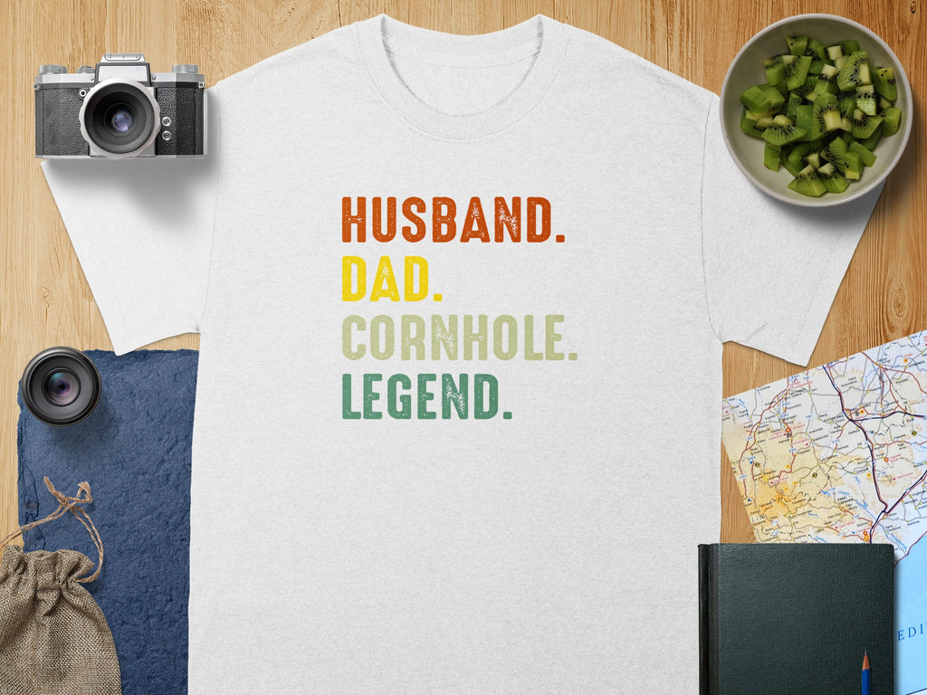 White t-shirt with "Husband. Dad. Cornhole. Legend." text in colored block letters.