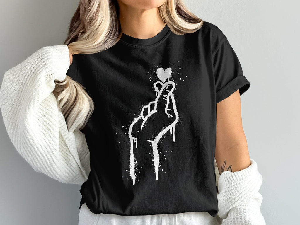 Black t-shirt with white graffiti-style finger heart and heart graphic.