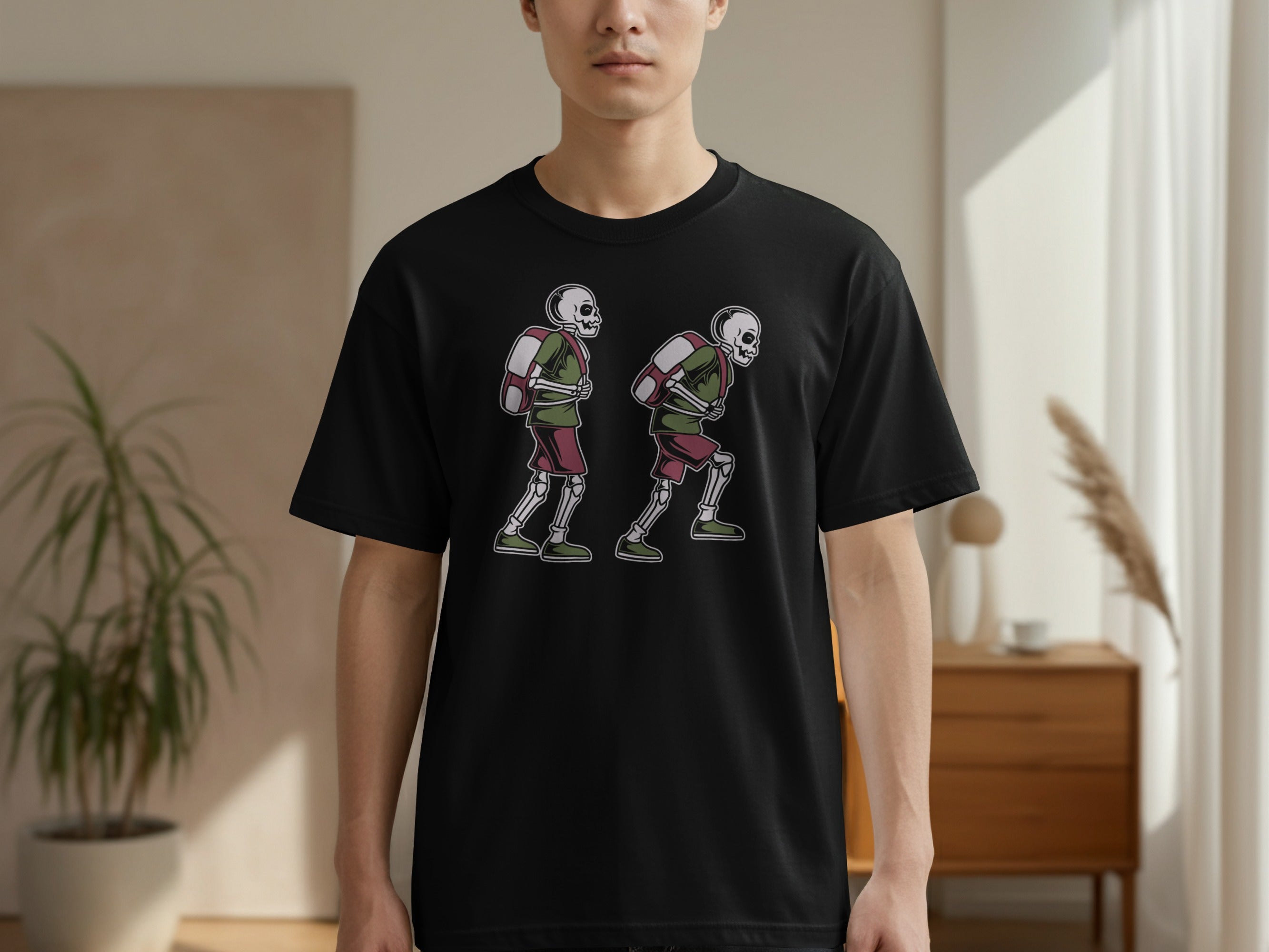 Black t-shirt with graphic of two skeletons wearing backpacks and athletic wear.