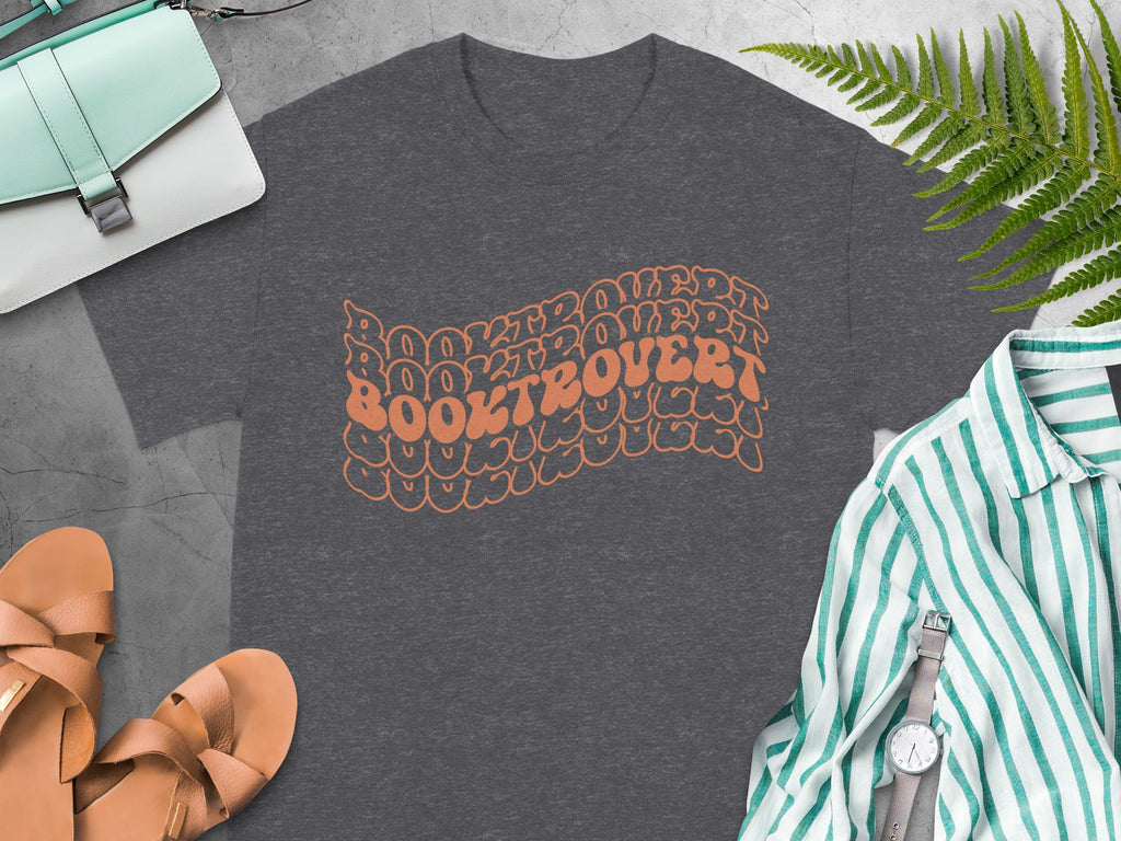 Dark gray t-shirt with wavy orange "BOOKTROVERT" text and surrounding graphic.
