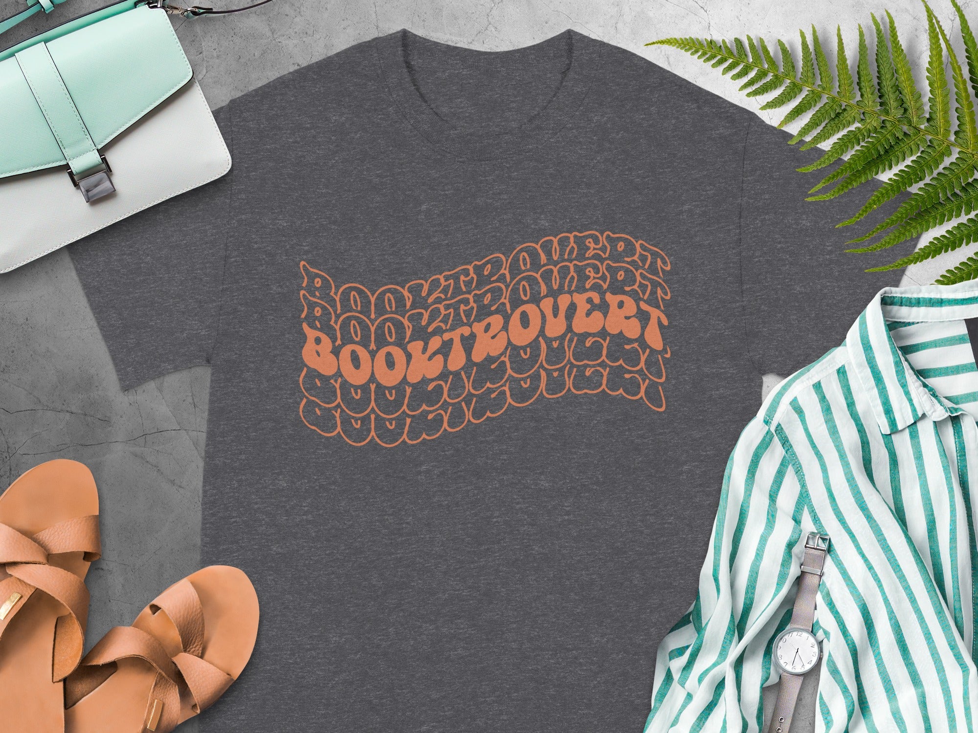 Dark gray t-shirt with wavy orange "BOOKTROVERT" text and surrounding graphic.