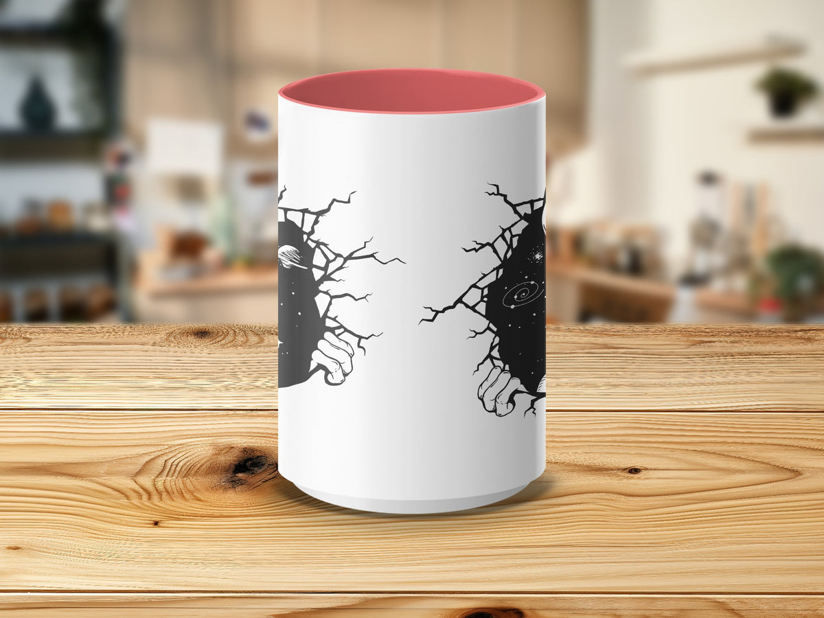 White mug with a pink interior, featuring cracking black graphic of hands reaching out from space.