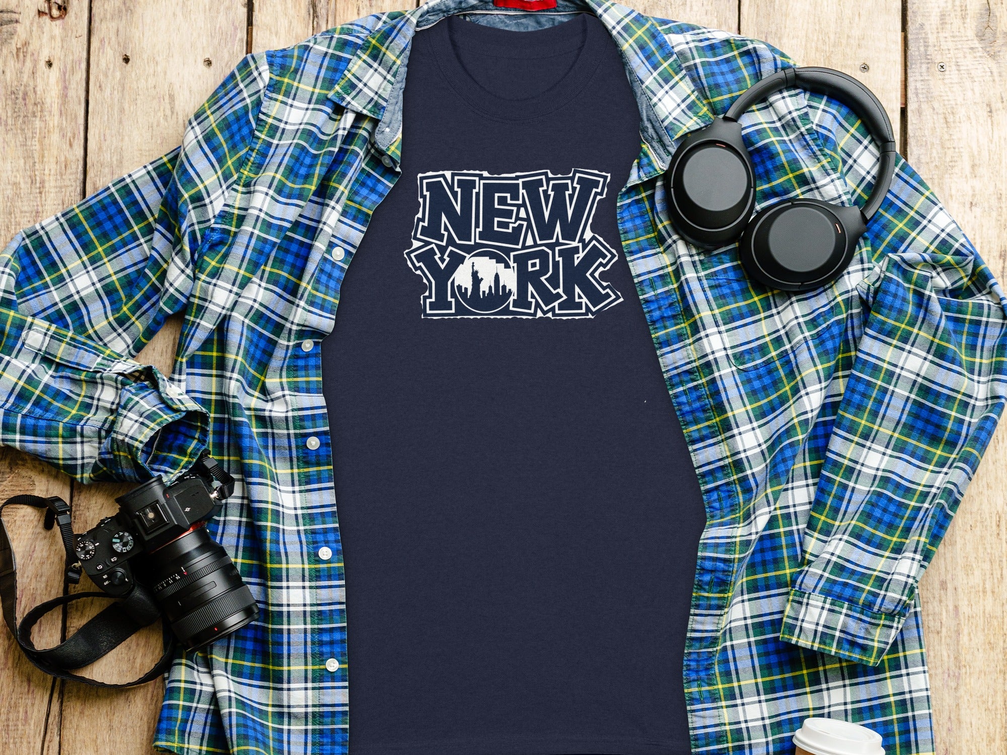 Navy t-shirt with "New York" text and skyline graphic, layered with plaid shirt.