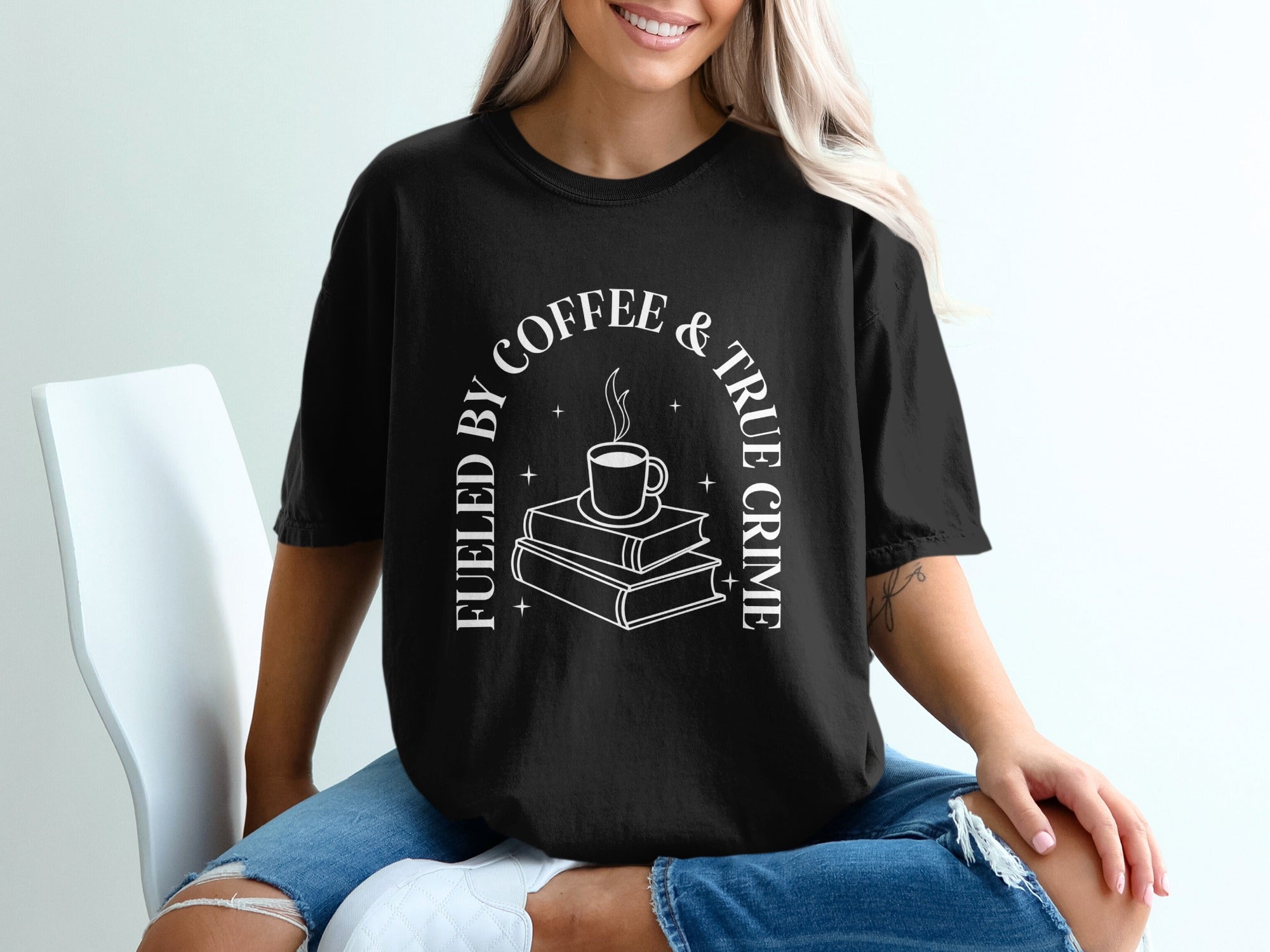 Black t-shirt with "Fueled by coffee & true crime" text and book stack graphic.