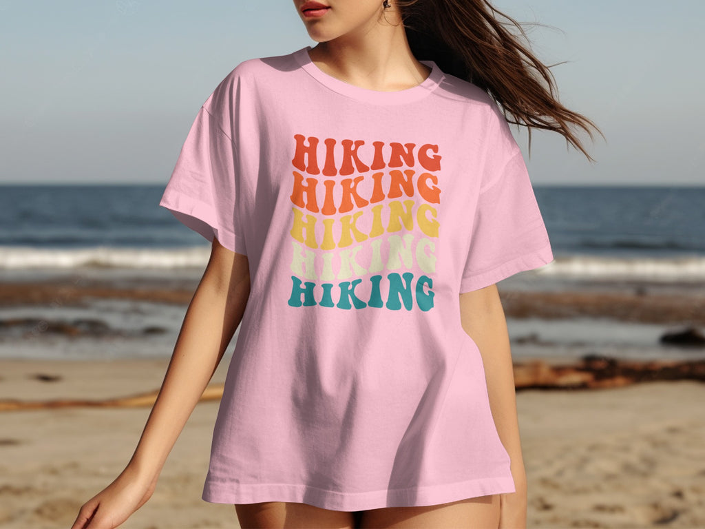 Pink t-shirt with stacked colorful text that reads "Hiking".