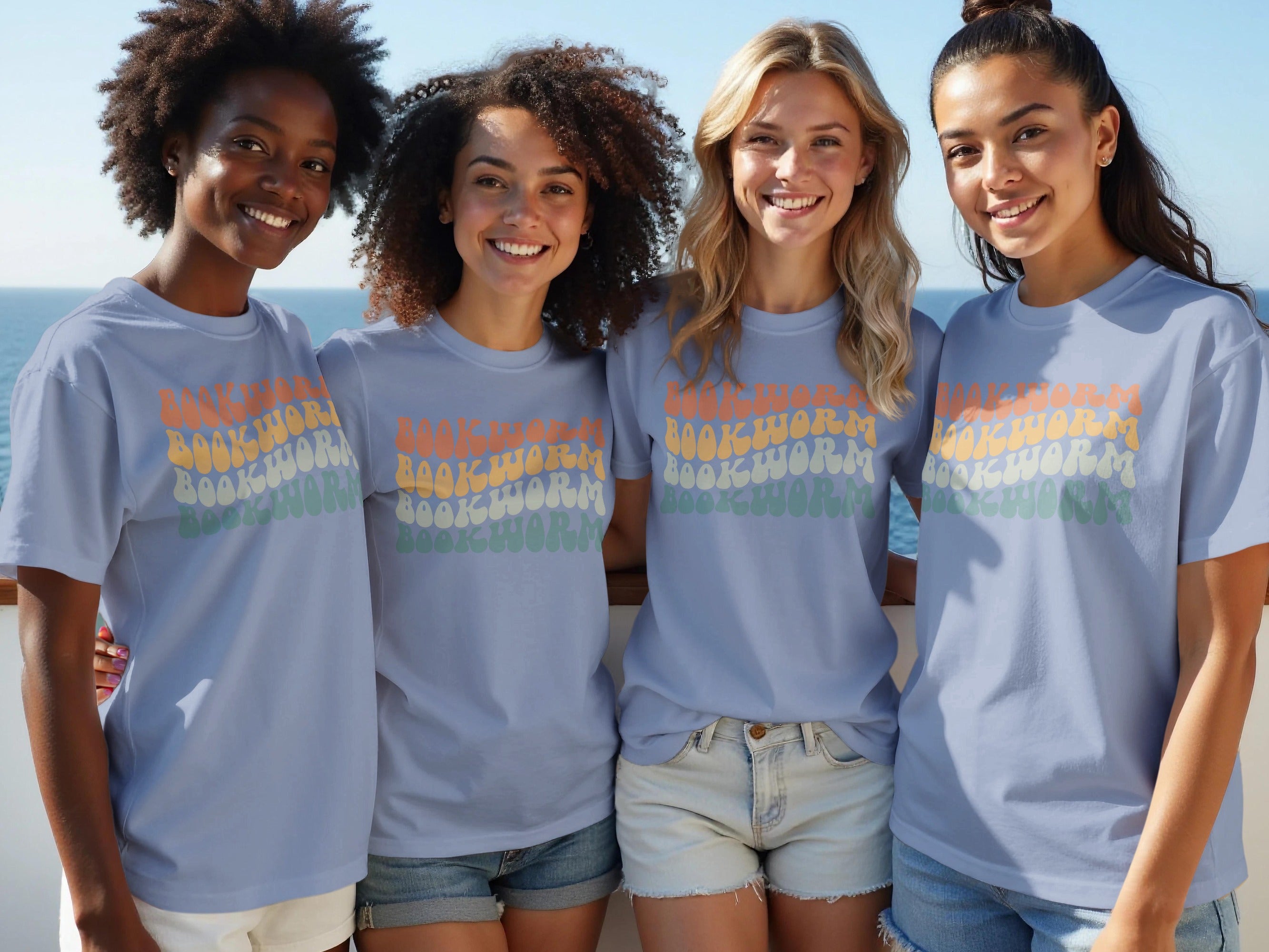 Four women wearing light blue t-shirts with "BOOKWORM" in retro lettering.