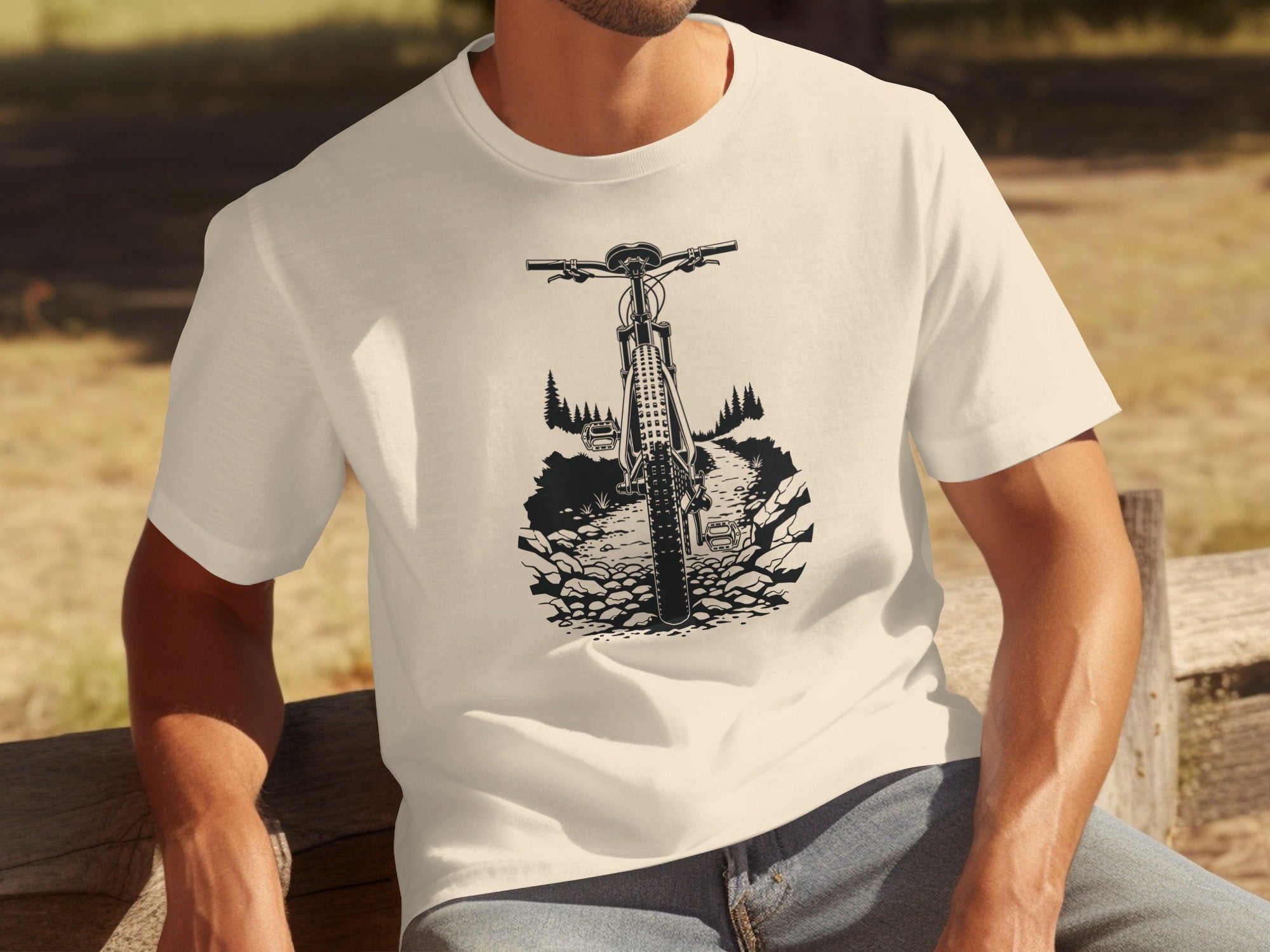 Cream t-shirt with black graphic of a mountain bike on a rocky trail.