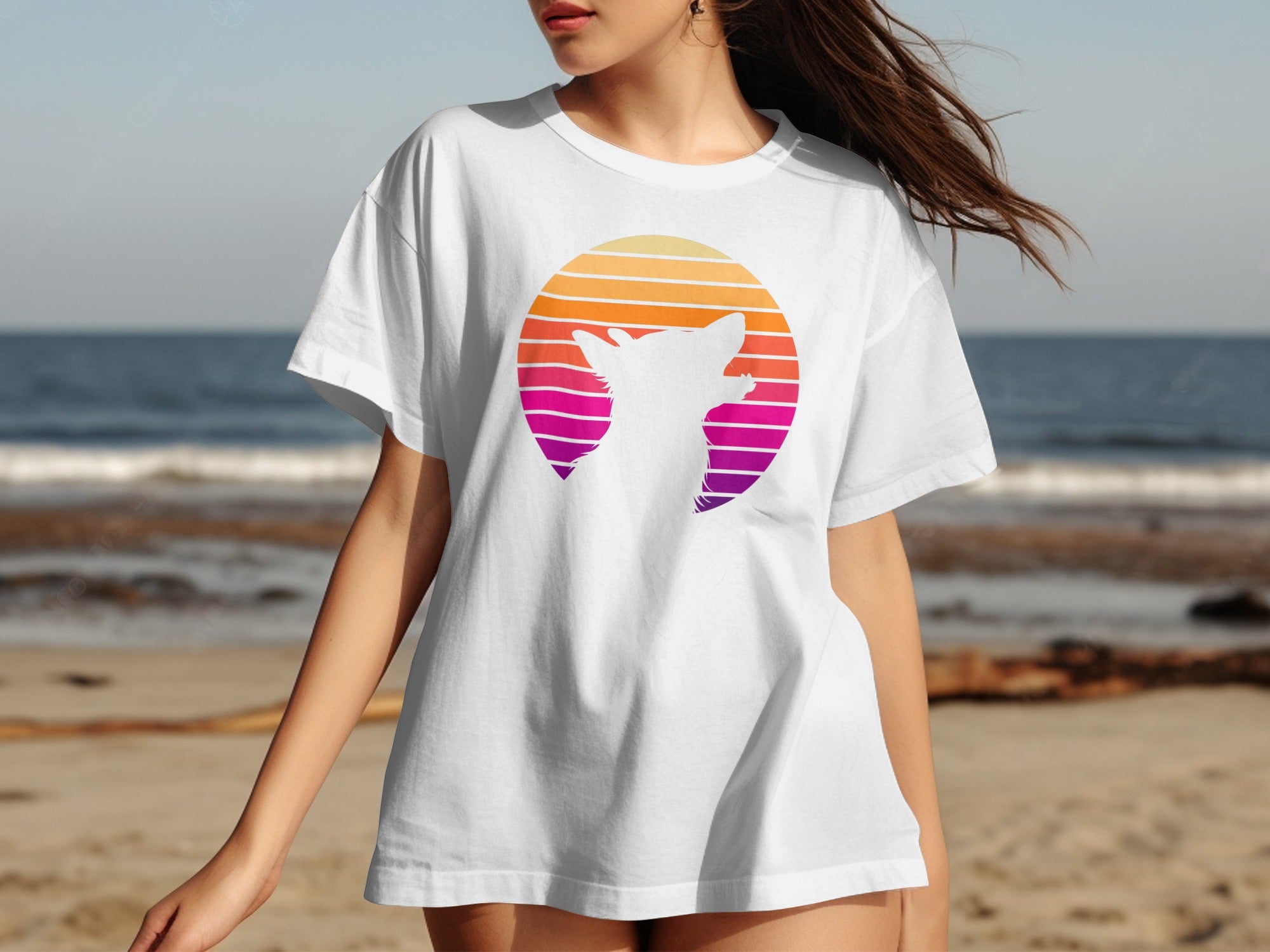 White t-shirt with gradient circle and cat silhouette graphic on a beach.
