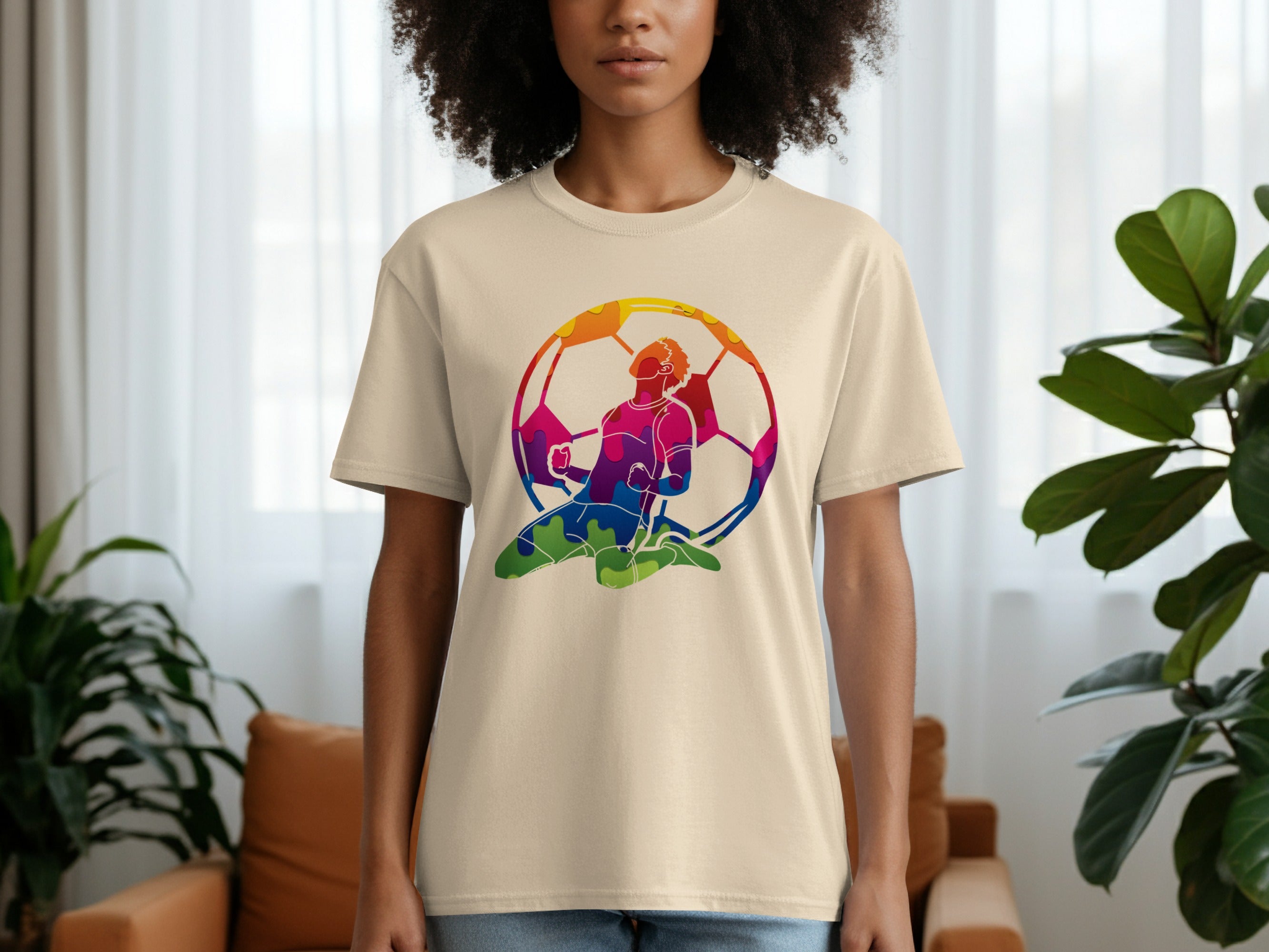 Cream t-shirt with a colorful soccer player celebrating inside of a soccer ball.