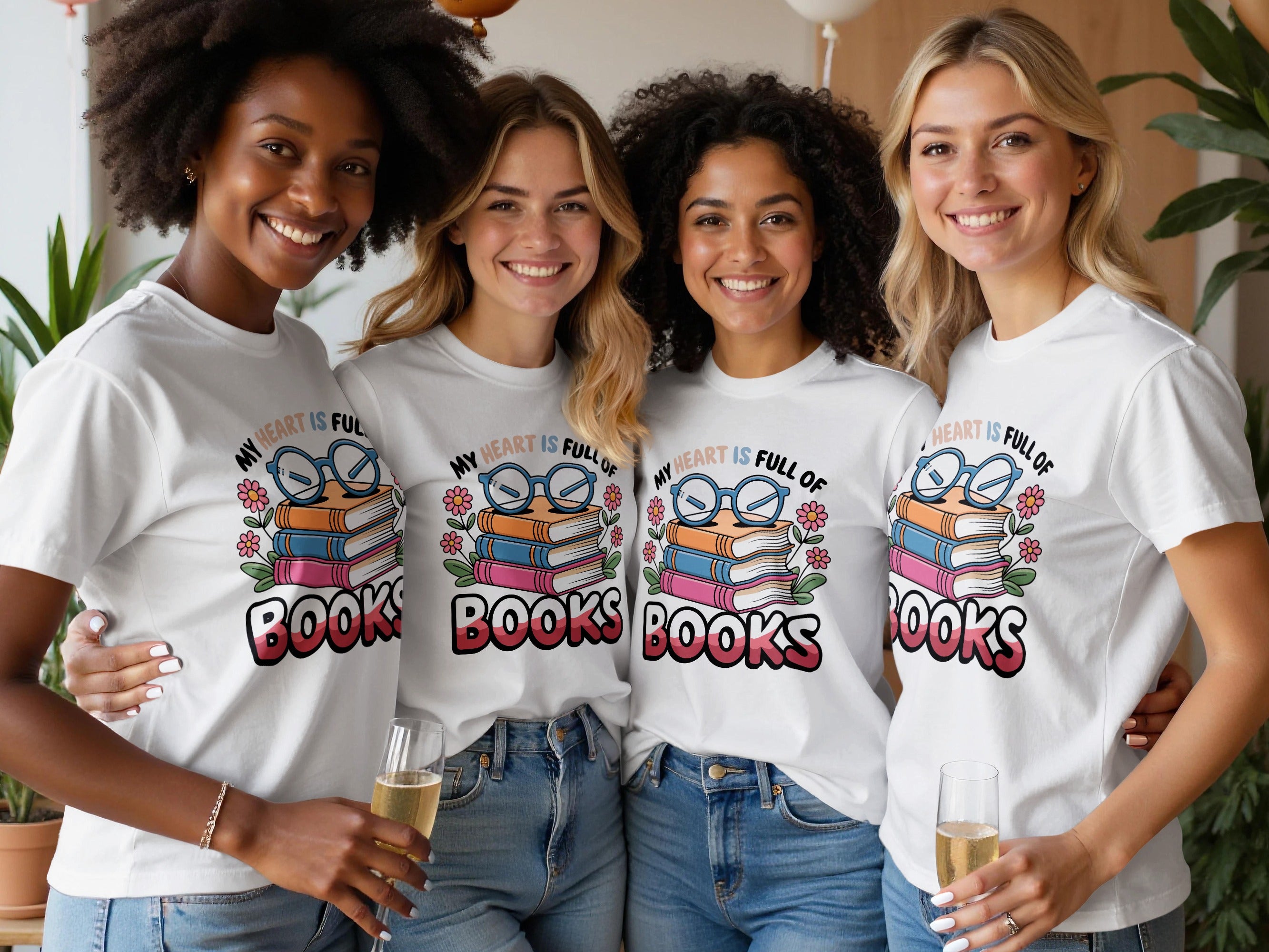 Four smiling women in white t-shirts featuring a graphic about books.