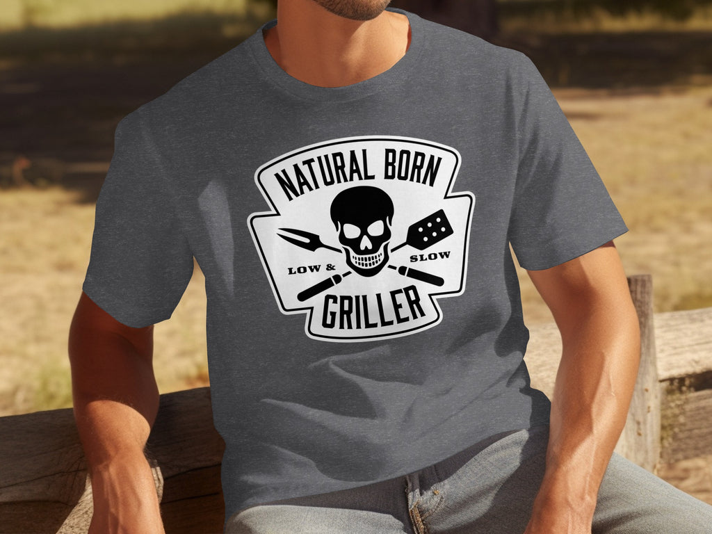 Gray t-shirt with a black graphic featuring a skull, barbecue tools, and text "Natural Born Griller Low and Slow".