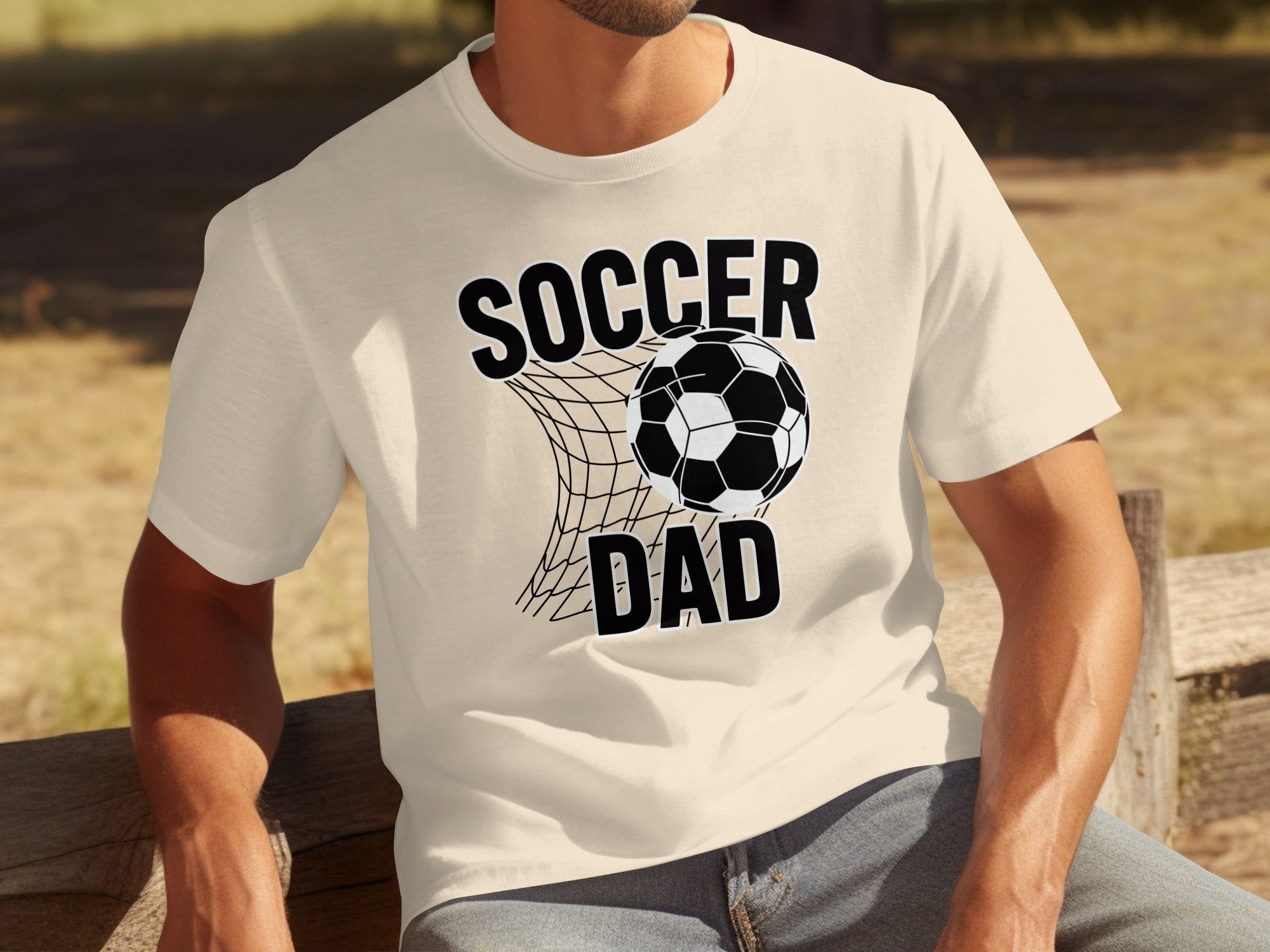 Light cream t-shirt with black text "SOCCER DAD" and a soccer ball in a net.