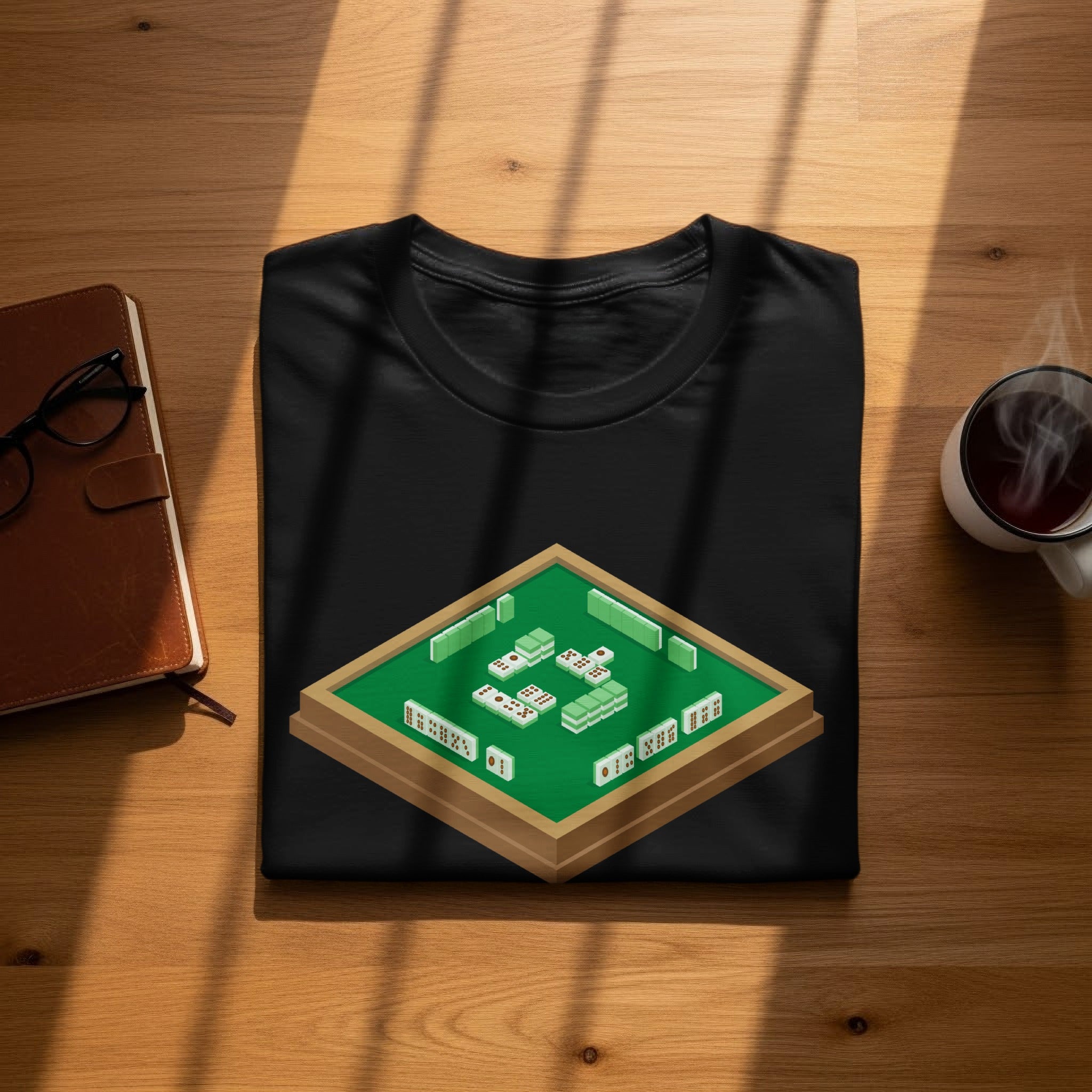 Black t-shirt with a mahjong tile design on a wooden table.
