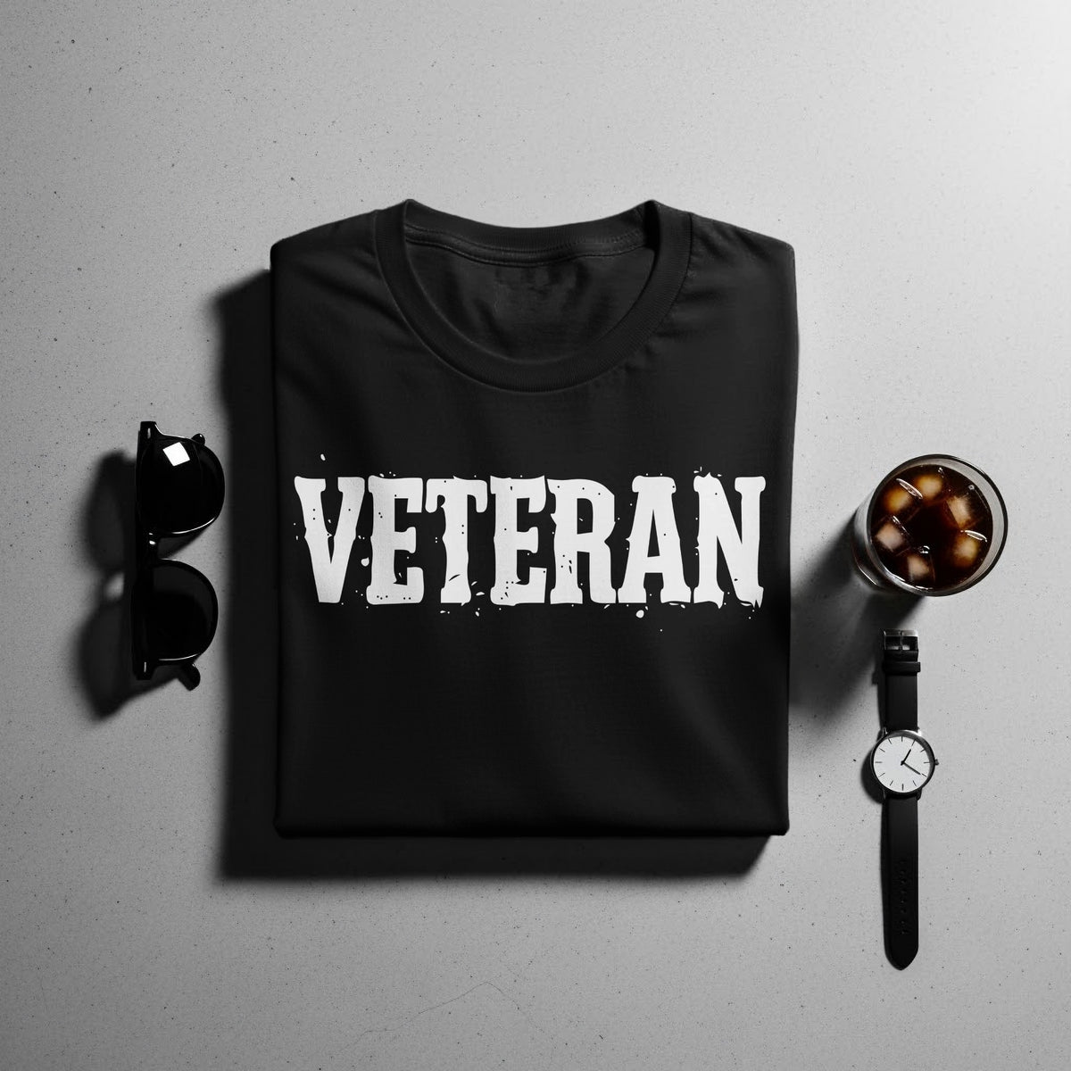 Black t-shirt with white "VETERAN" text, sunglasses, and a watch.