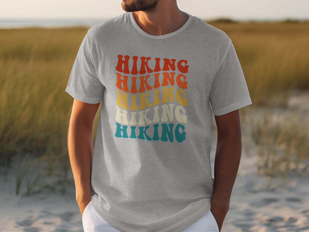 Grey t-shirt with repeated "Hiking" text in retro, wavy font and layered colors.