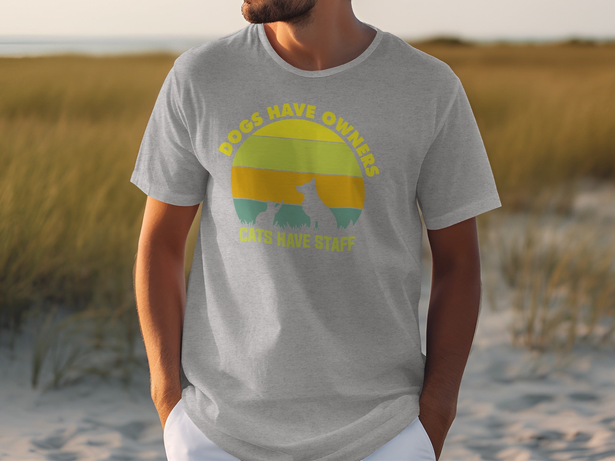 Grey t-shirt with a circular graphic of a dog and cat and text "Dogs have owners. Cats have staff."