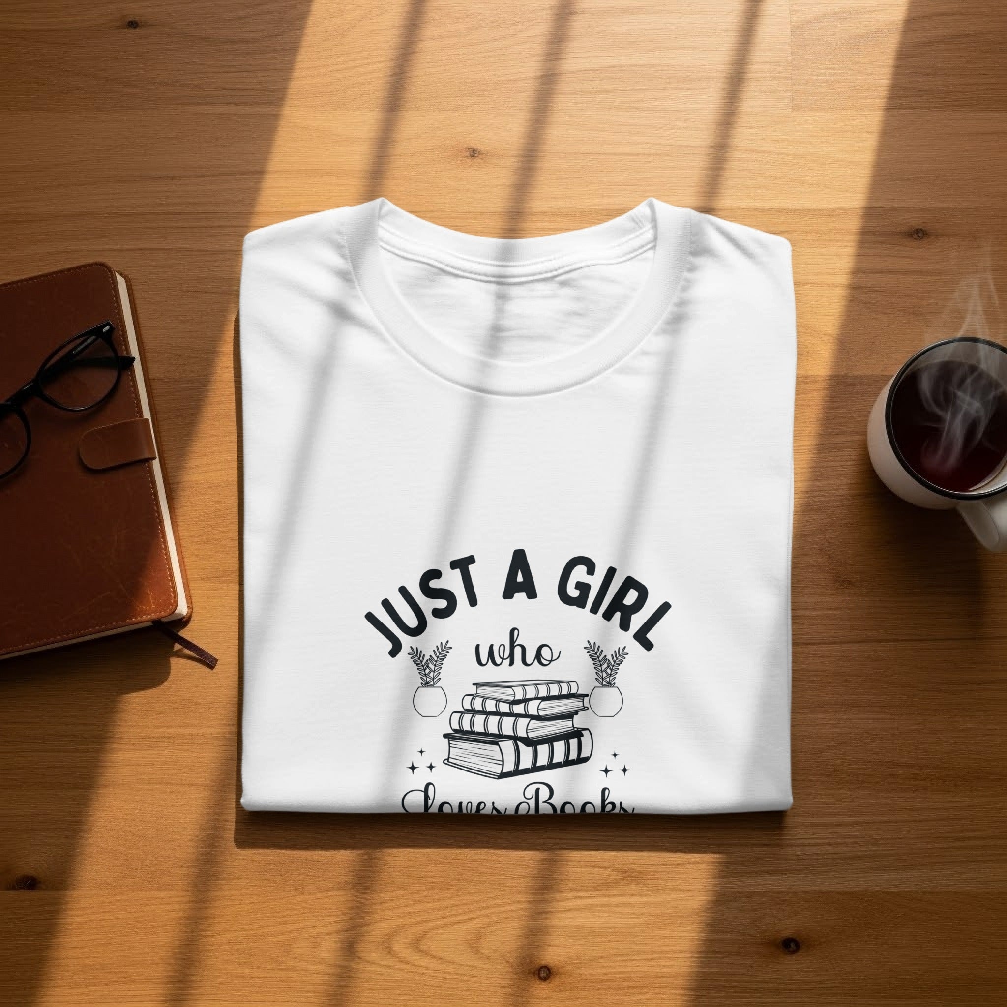 White t-shirt with black text "Just a girl who loves books" and book illustration.