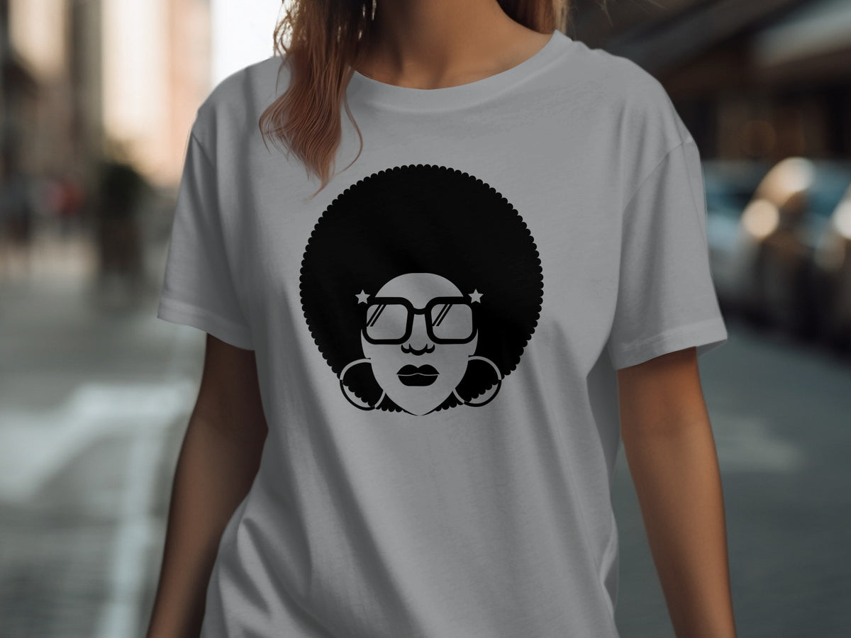 Black graphic of afro-haired woman wearing large glasses and hoop earrings on a grey t-shirt.