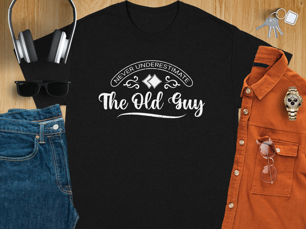 Black t-shirt with white text "Never Underestimate The Old Guy".