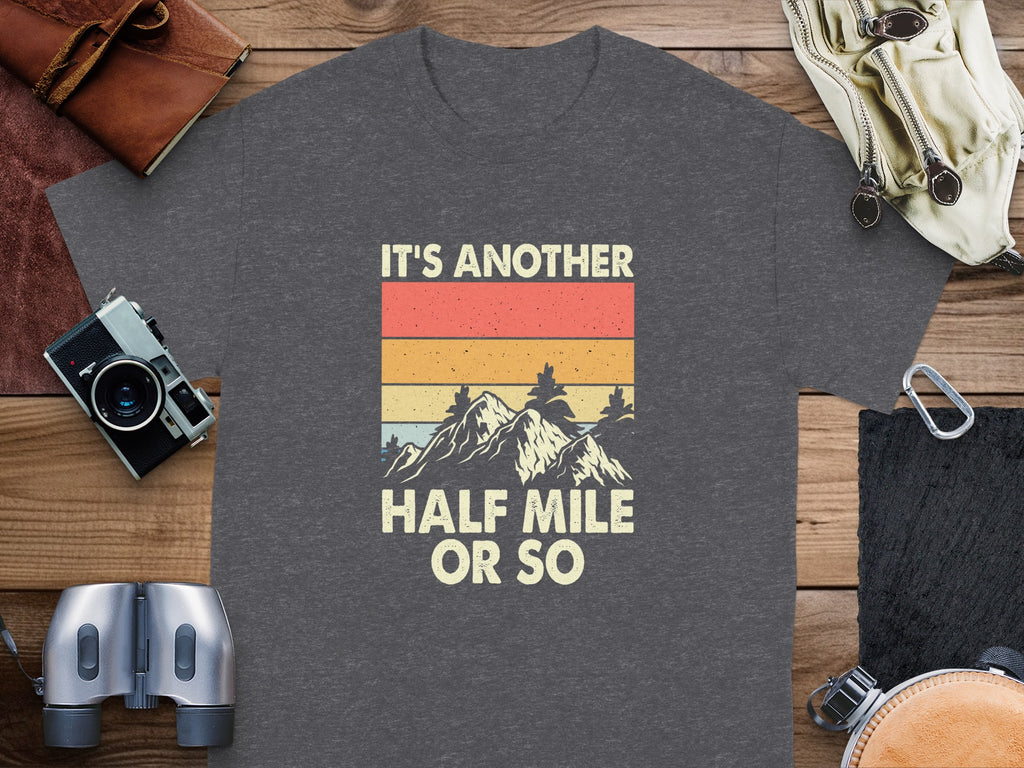 Dark grey t-shirt with text "IT'S ANOTHER HALF MILE OR SO" and mountain graphic.