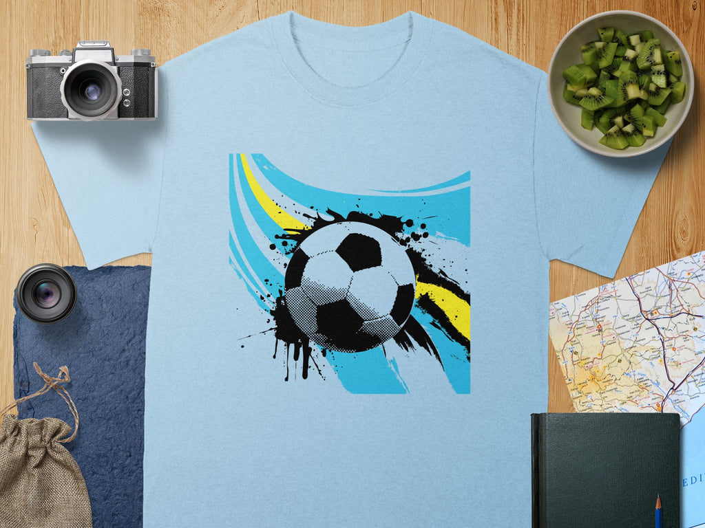 Light blue t-shirt with a graphic of a soccer ball and abstract paint splatters.