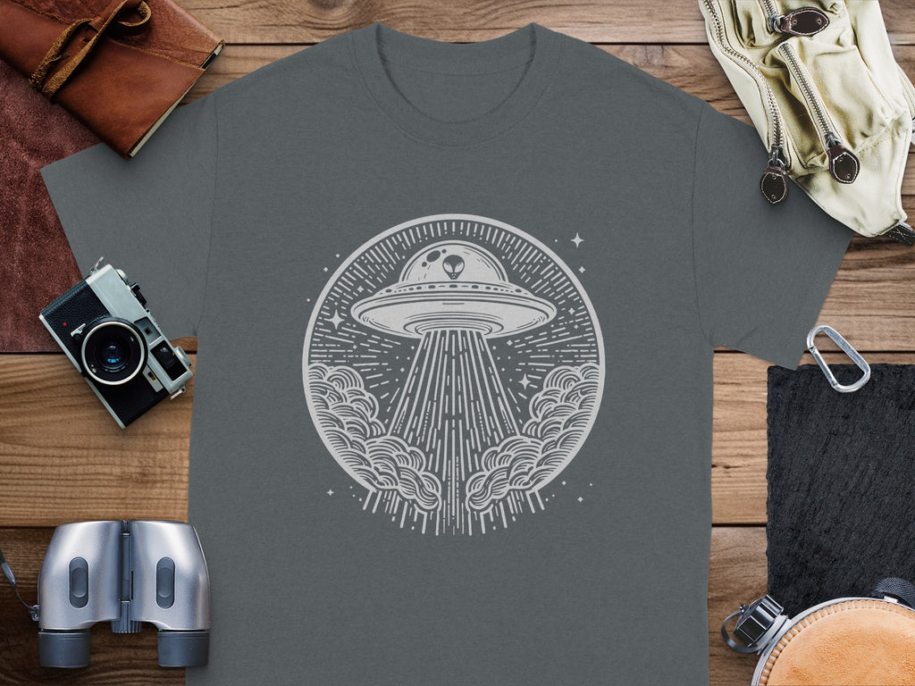 UFO with alien beaming light down from circular cloud design on gray t-shirt.