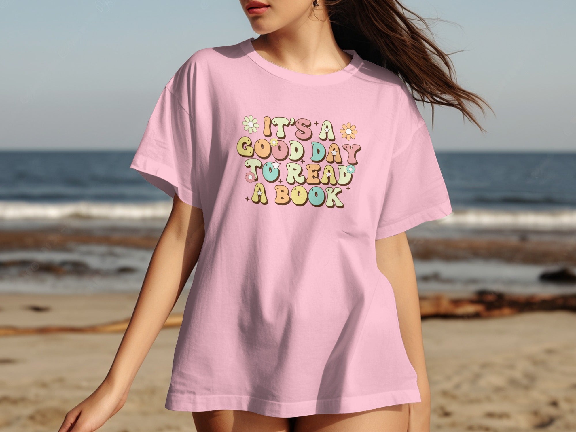 Pink t-shirt with "It's a good day to read a book" graphic and flowers.