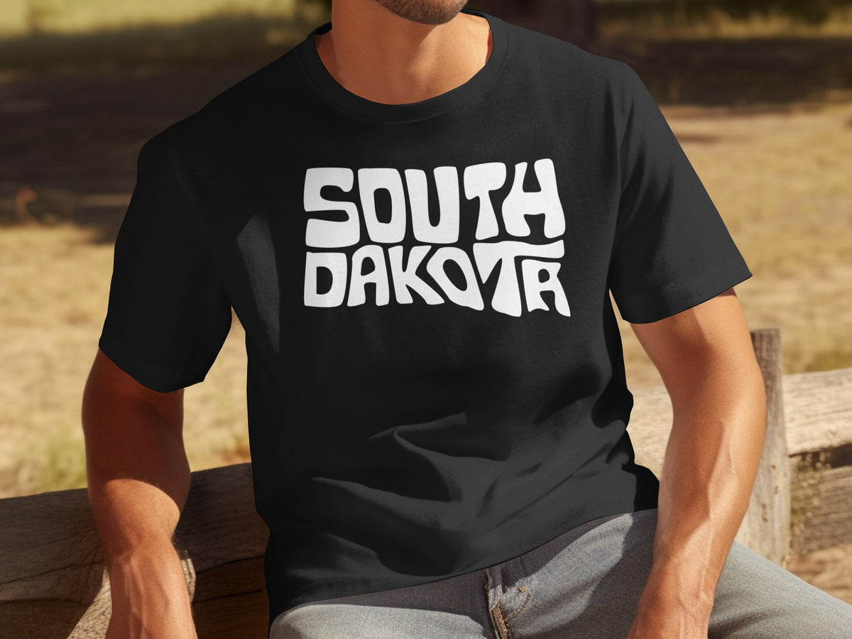 Black t-shirt with white "South Dakota" lettering in a wavy font.