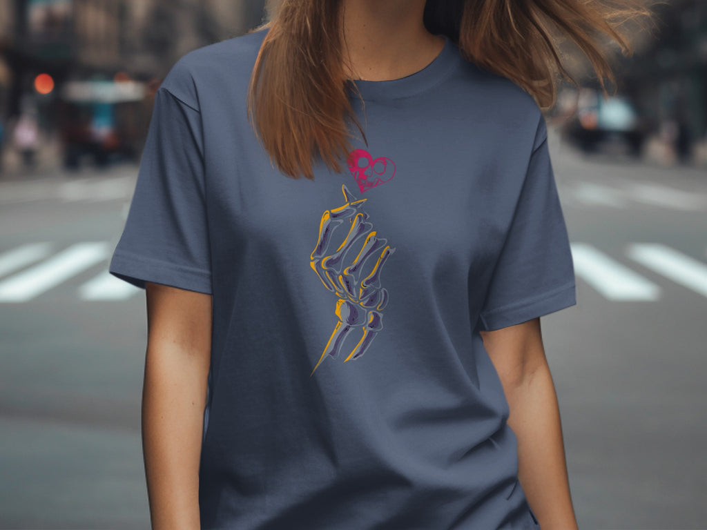 Skeleton hand holding a stylized heart with skull design on a blue t-shirt.