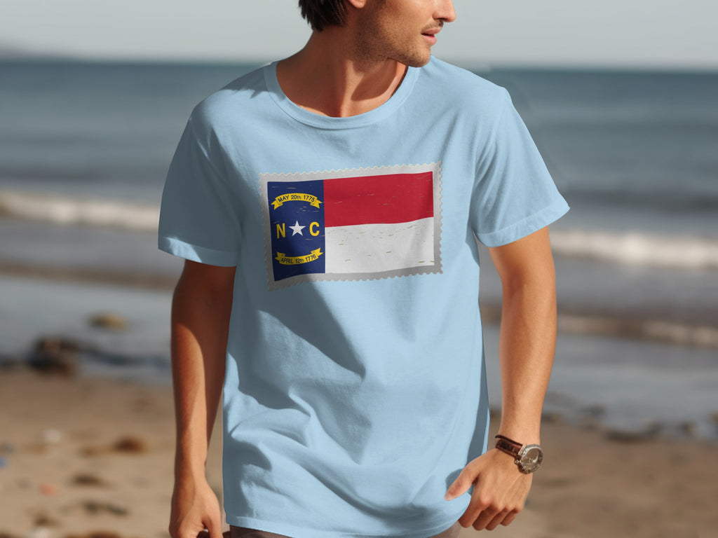Light blue t-shirt with North Carolina flag stamp design and text.