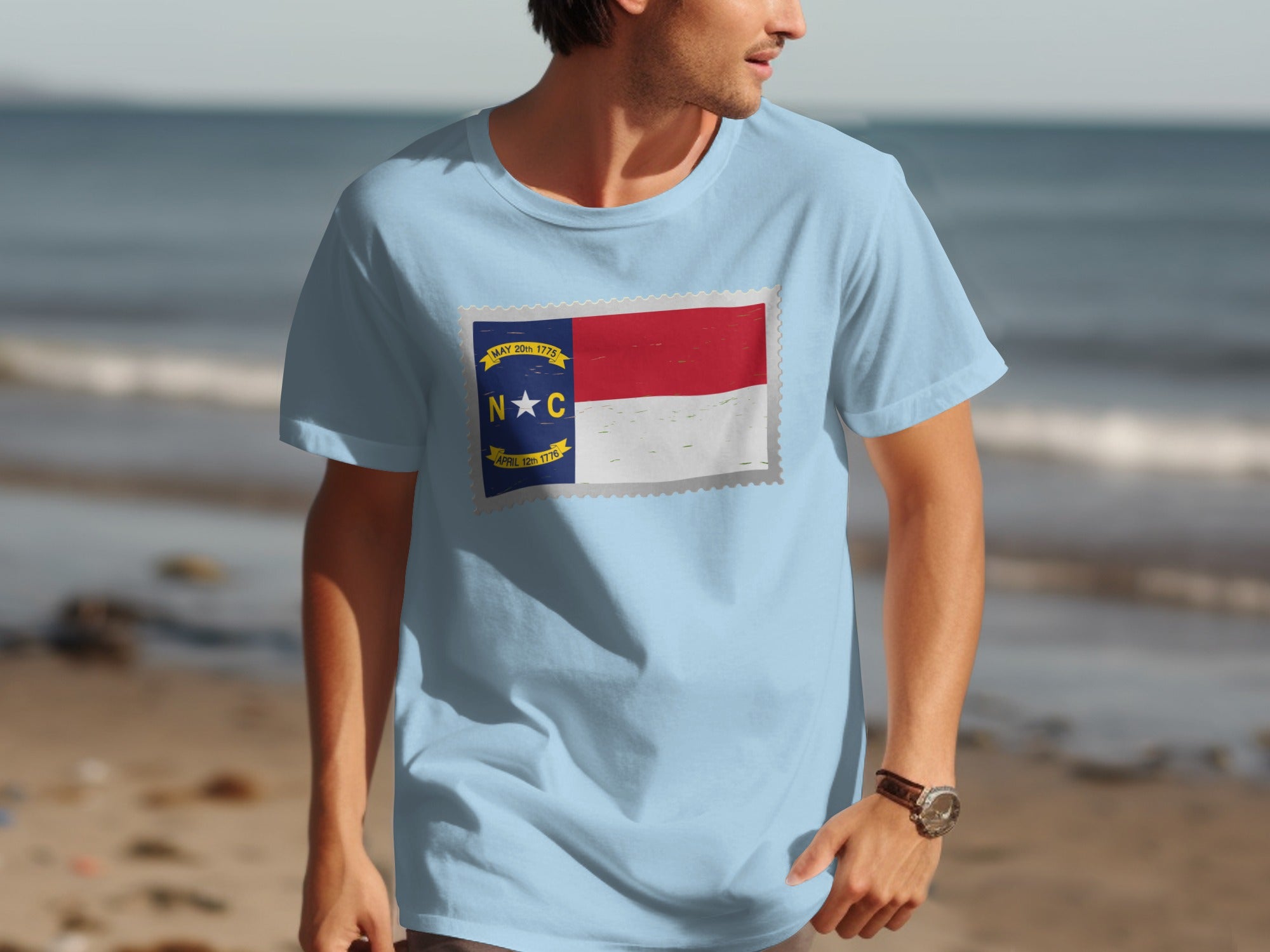 Light blue t-shirt with North Carolina flag stamp design and text.