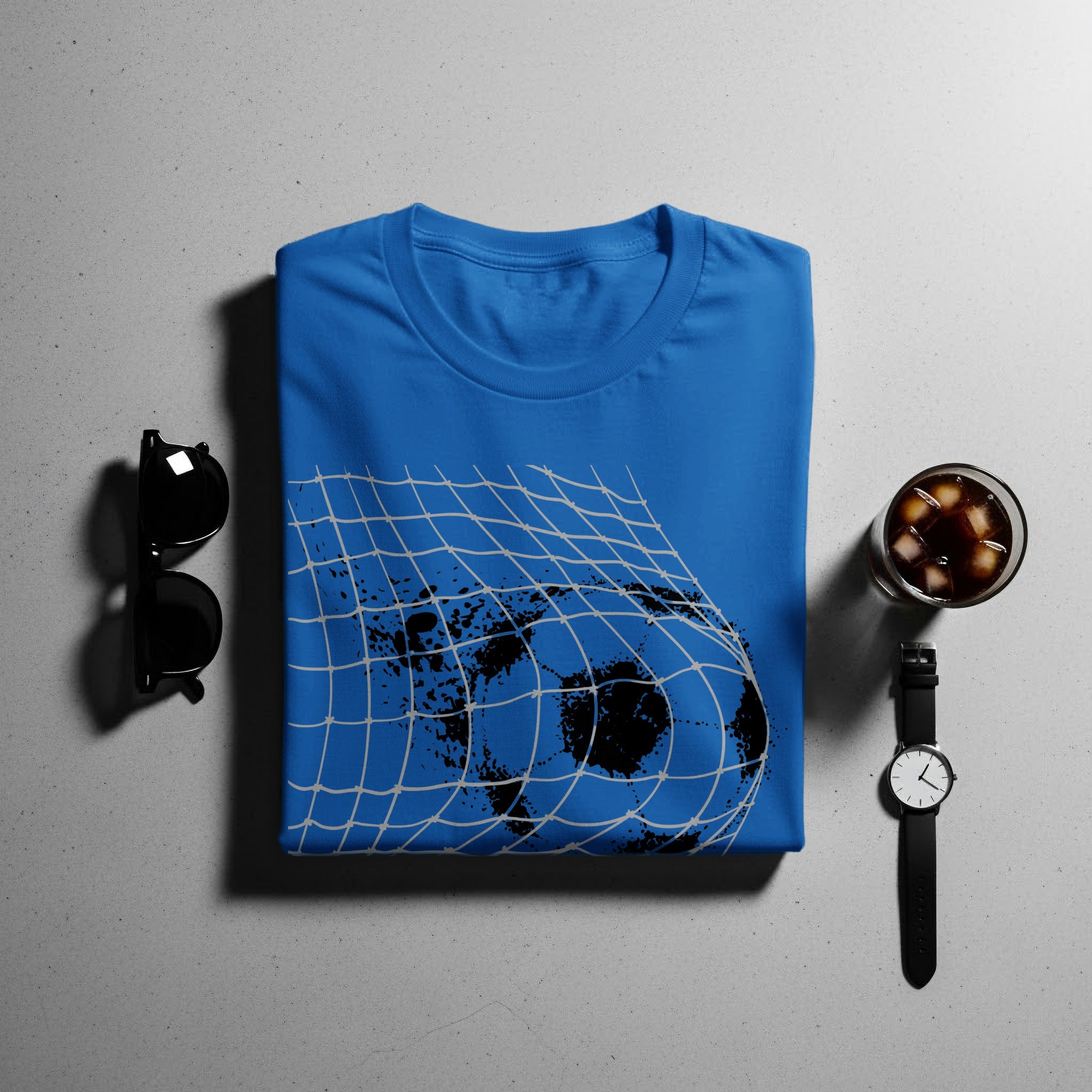 Blue t-shirt with black soccer ball and net graphic, sunglasses, cocktail, and watch.
