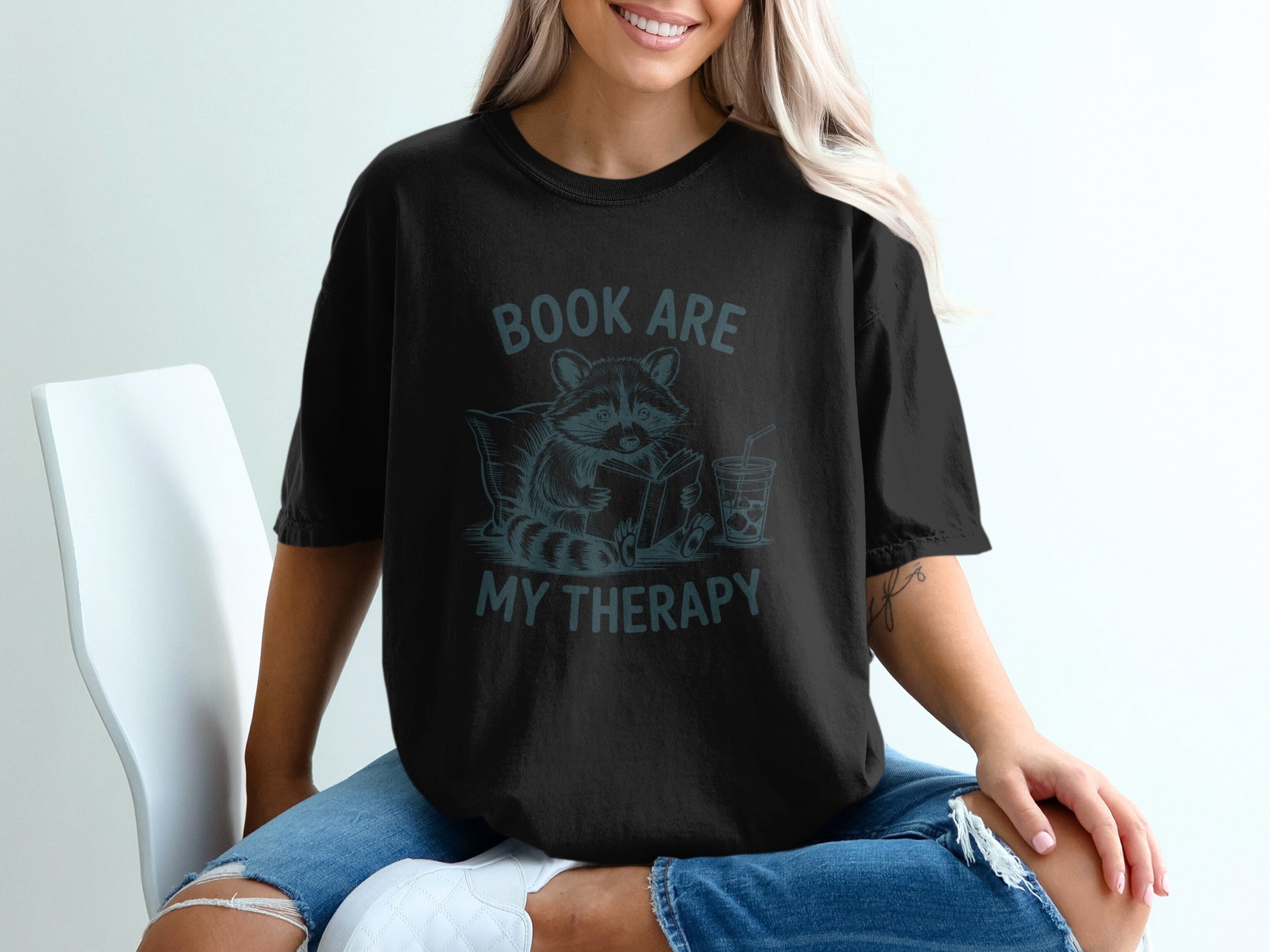 Black t-shirt with raccoon reading book and "Book Are My Therapy" text.