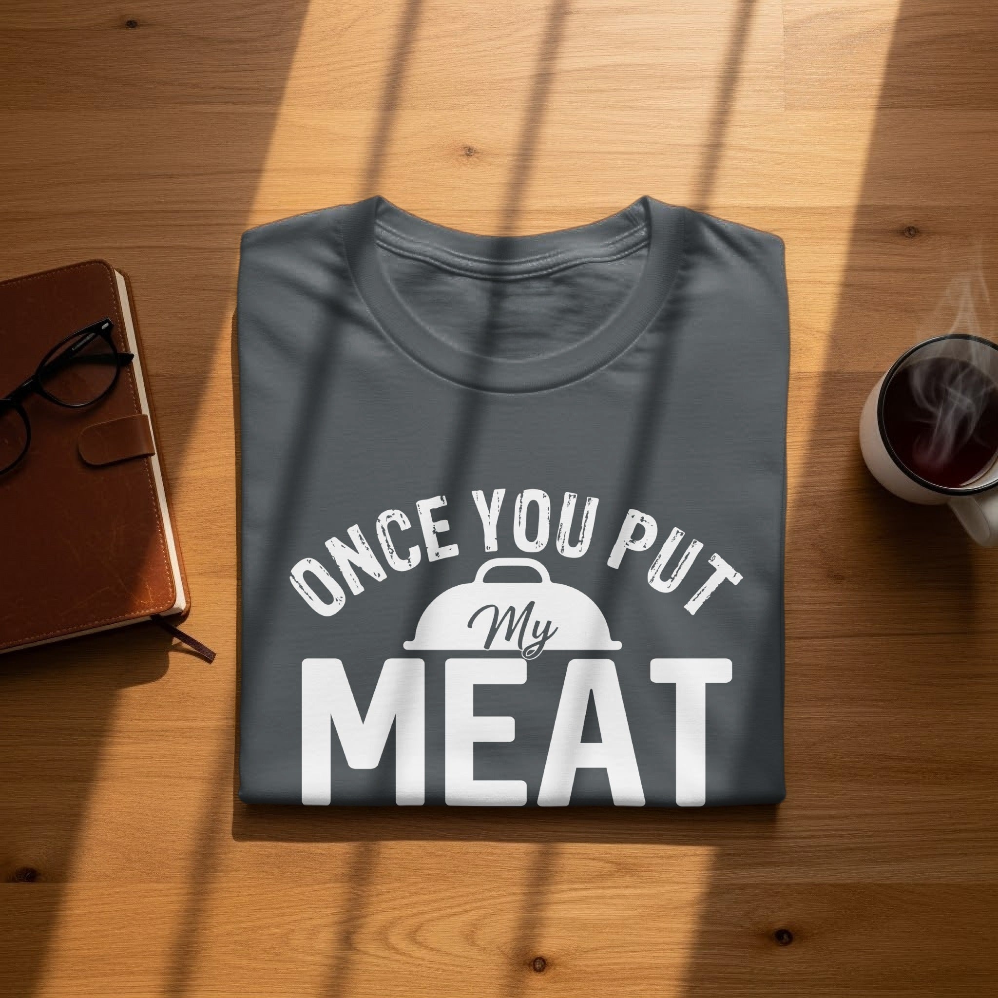 Dark gray t-shirt with "Once You Put My Meat" text and a grill icon.