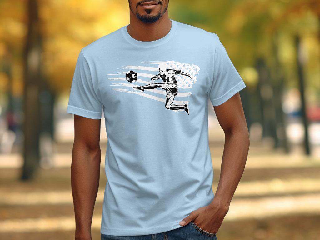Light blue T-shirt with graphic of soccer player kicking ball, American flag design.