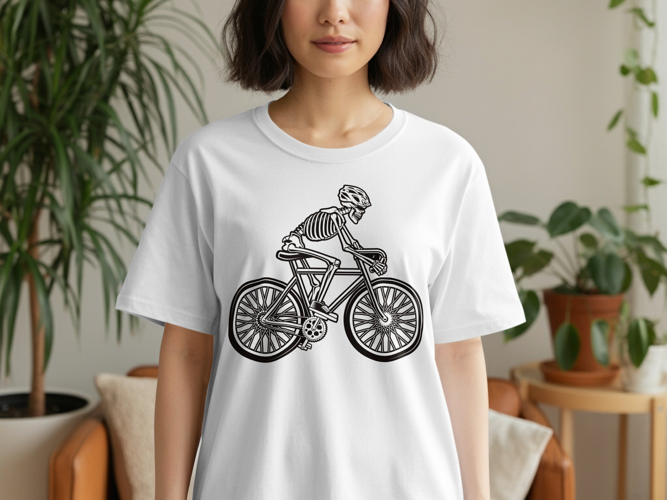 White t-shirt with black graphic of a skeleton riding a bicycle.