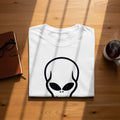 White t-shirt with a black alien head graphic and a steaming mug of coffee.