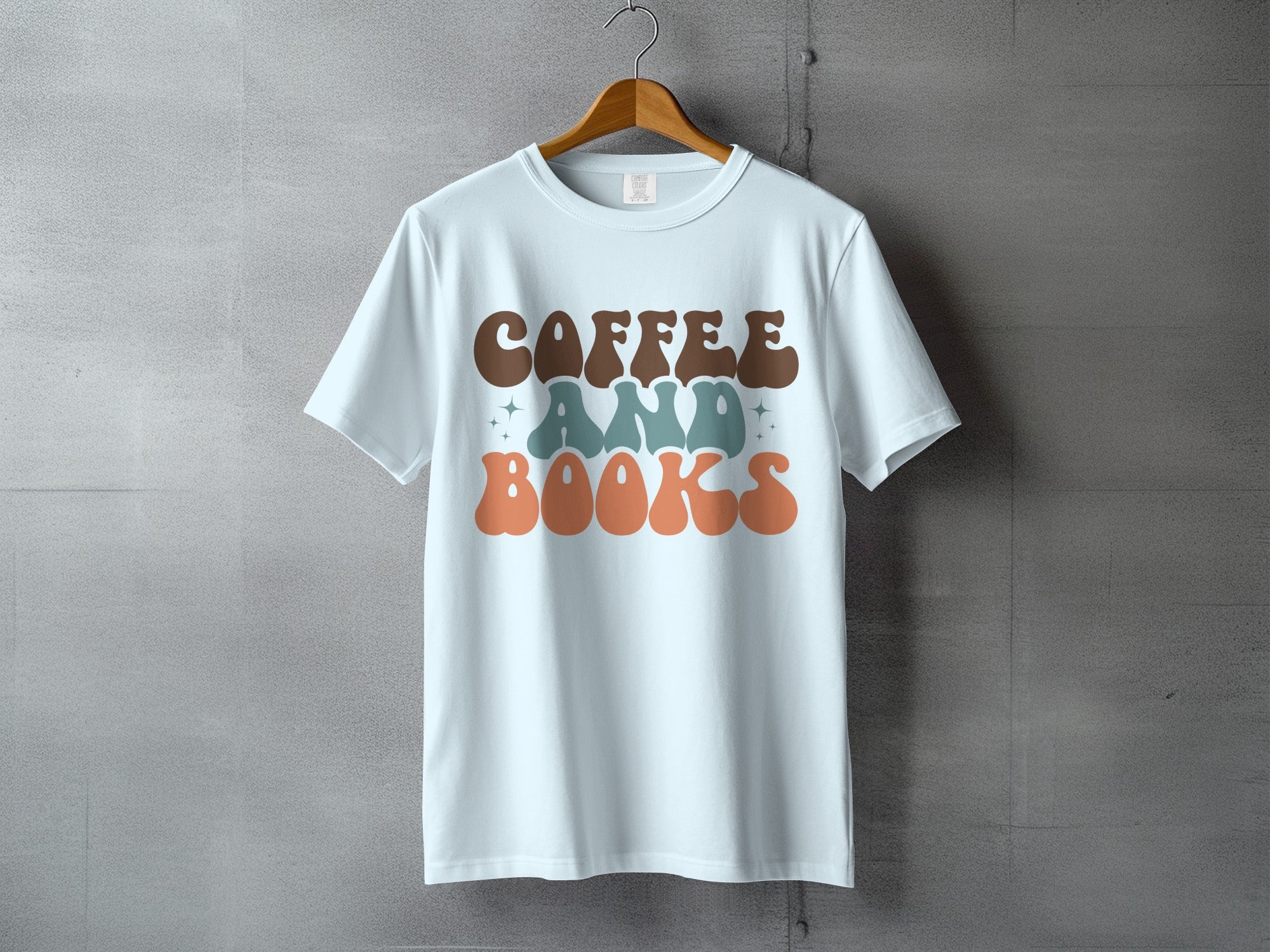 Light blue t-shirt with stacked text reading "coffee AND books" in retro fonts.