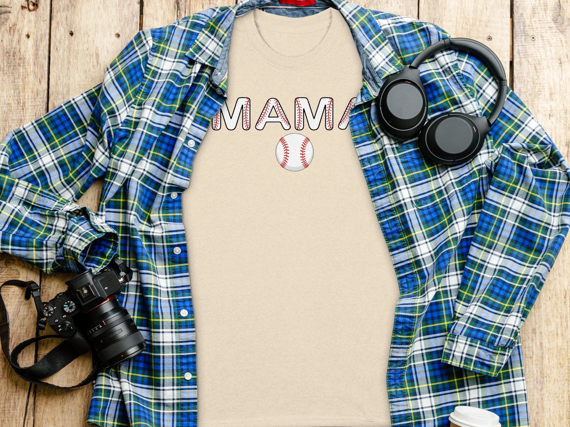 Beige t-shirt with "MAMA" text and baseball graphic, layered with plaid shirt.
