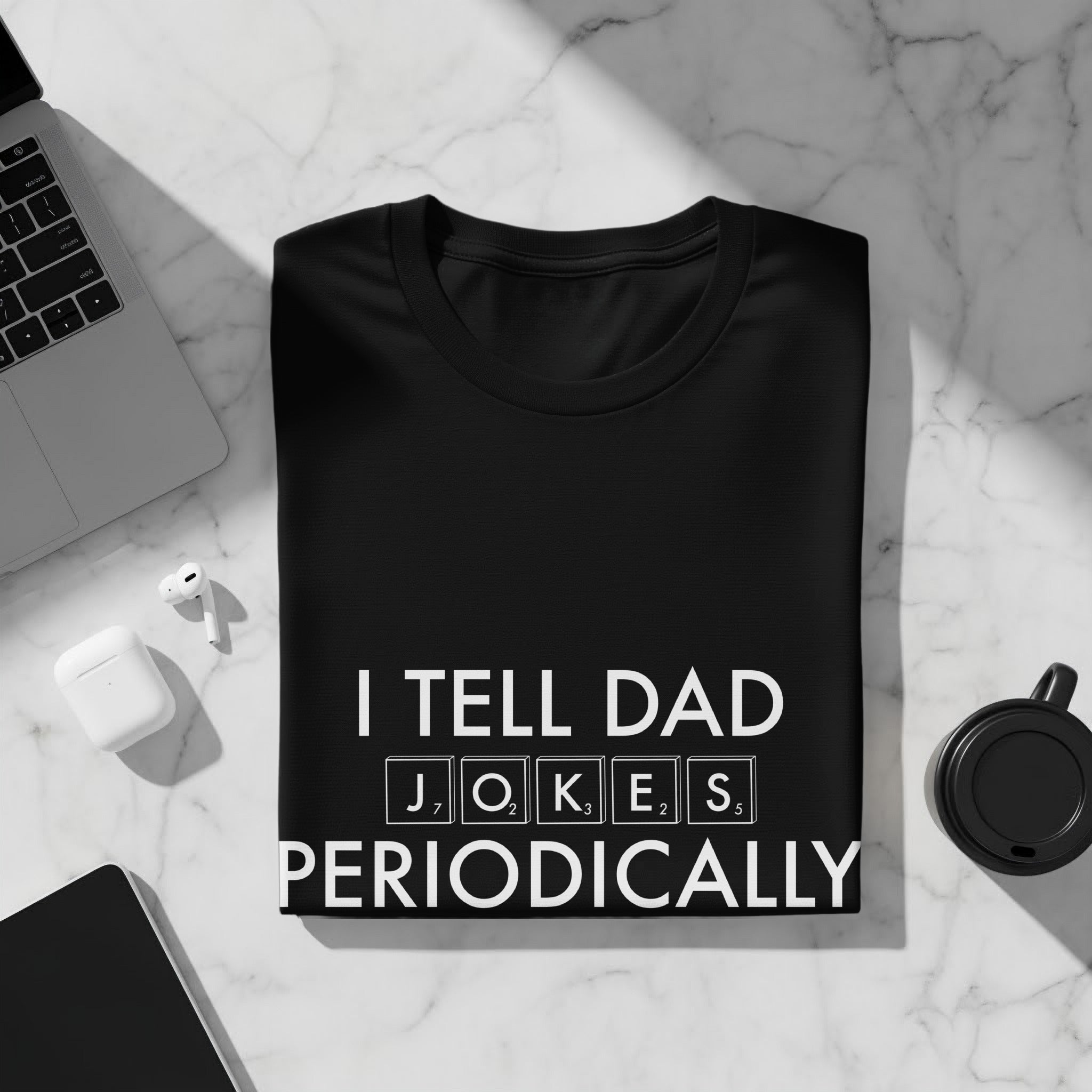 Black t-shirt with white text "I TELL DAD JOKES PERIODICALLY" in Scrabble tiles font.