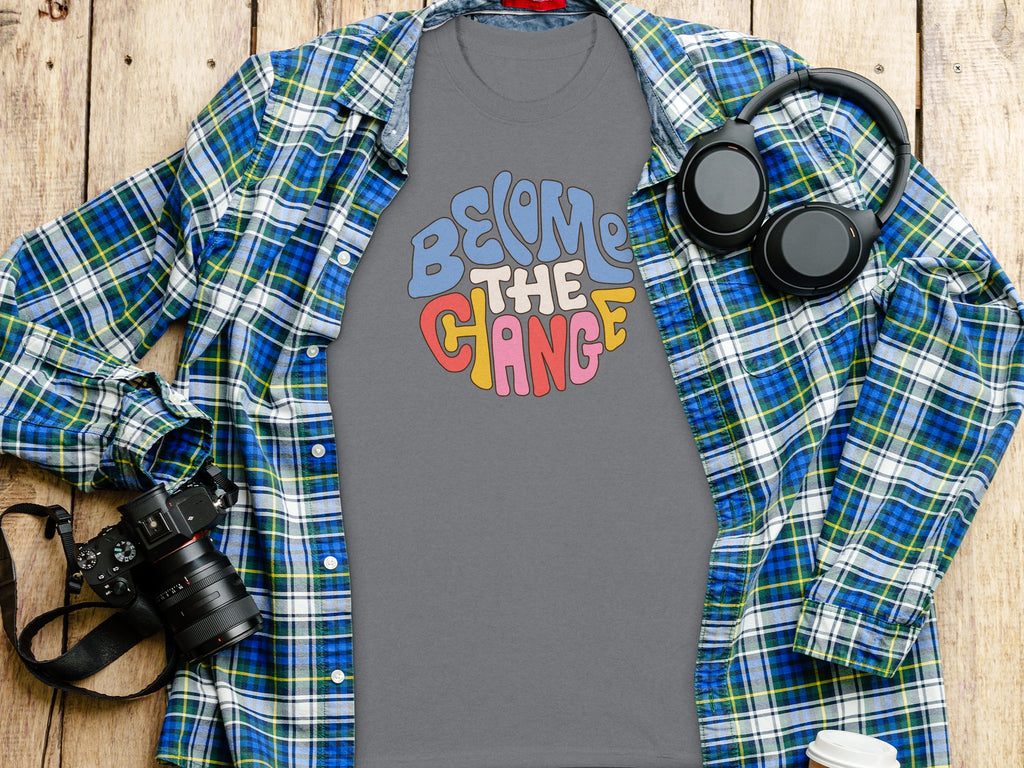 T-shirt with "Become the Change" graphic, plaid shirt, headphones, and camera.