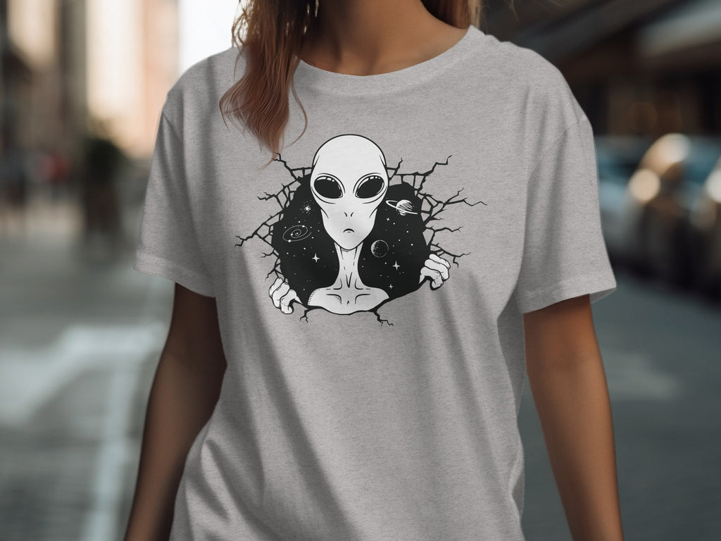 Grey t-shirt with a black illustration of an alien bursting through a cracked space background.