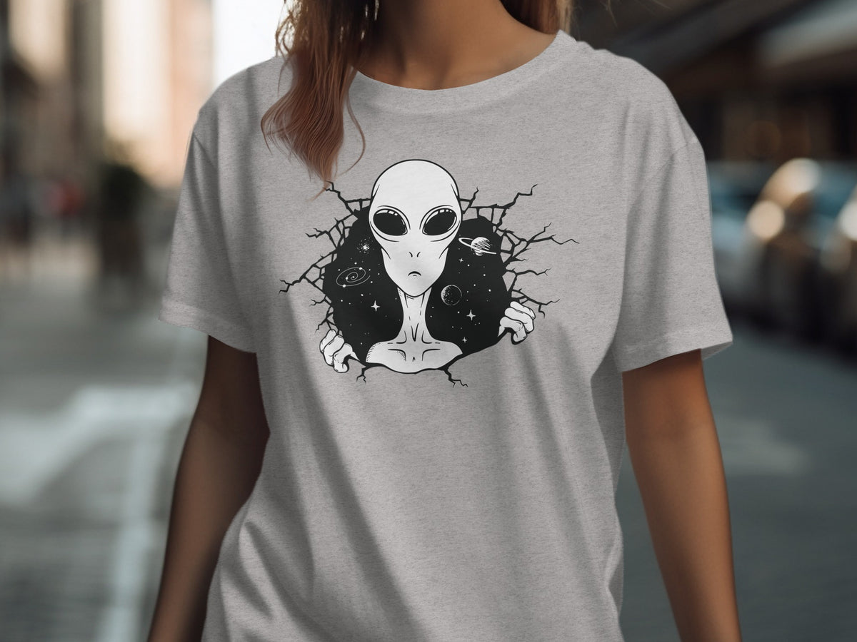 Grey t-shirt with a black illustration of an alien bursting through a cracked space background.