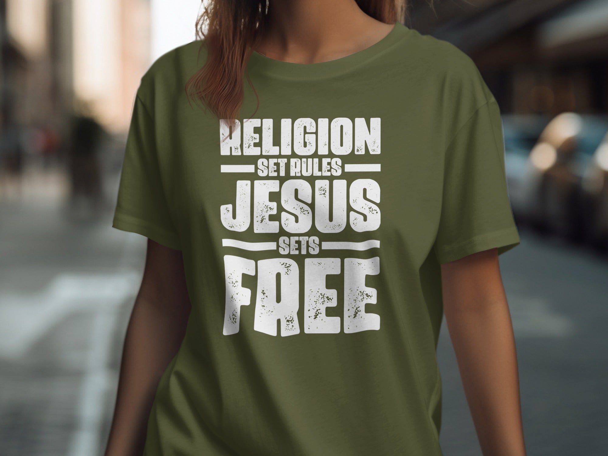 Olive green t-shirt with white distressed text: "RELIGION SET RULES JESUS SETS FREE"