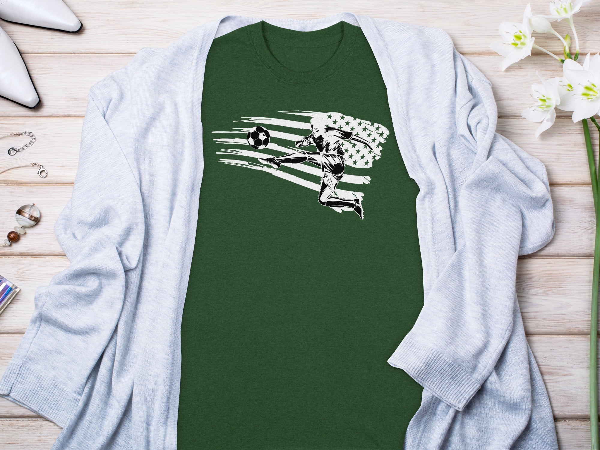 Green t-shirt with soccer player kicking ball against distressed American flag graphic.