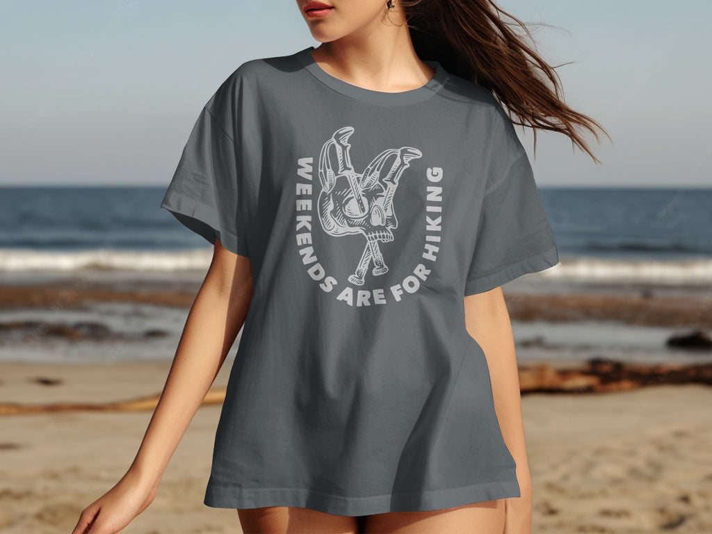 Grey t-shirt with white graphic of skull and crossed hiking poles, text "weekends are for hiking".