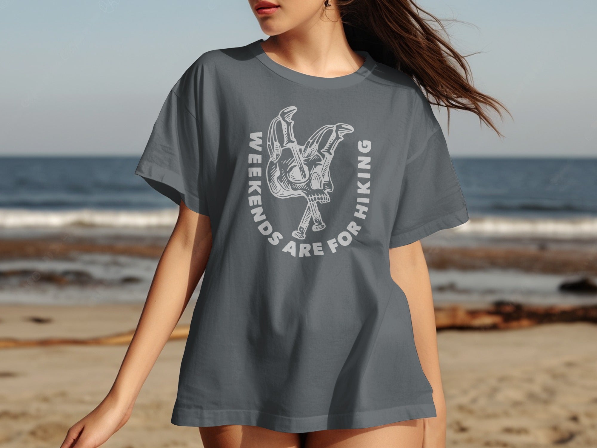 Grey t-shirt with white graphic of skull and crossed hiking poles, text "weekends are for hiking".