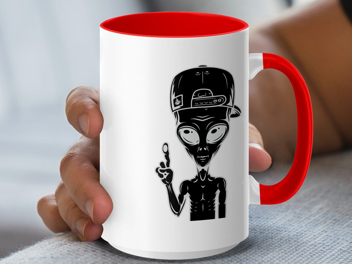 White mug with red handle featuring a black alien graphic wearing a backwards baseball cap.