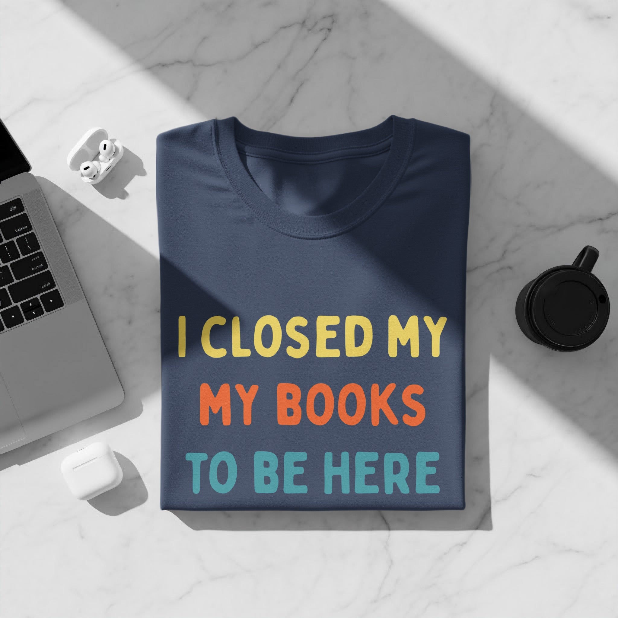 Navy t-shirt with "I CLOSED MY MY BOOKS TO BE HERE" text.