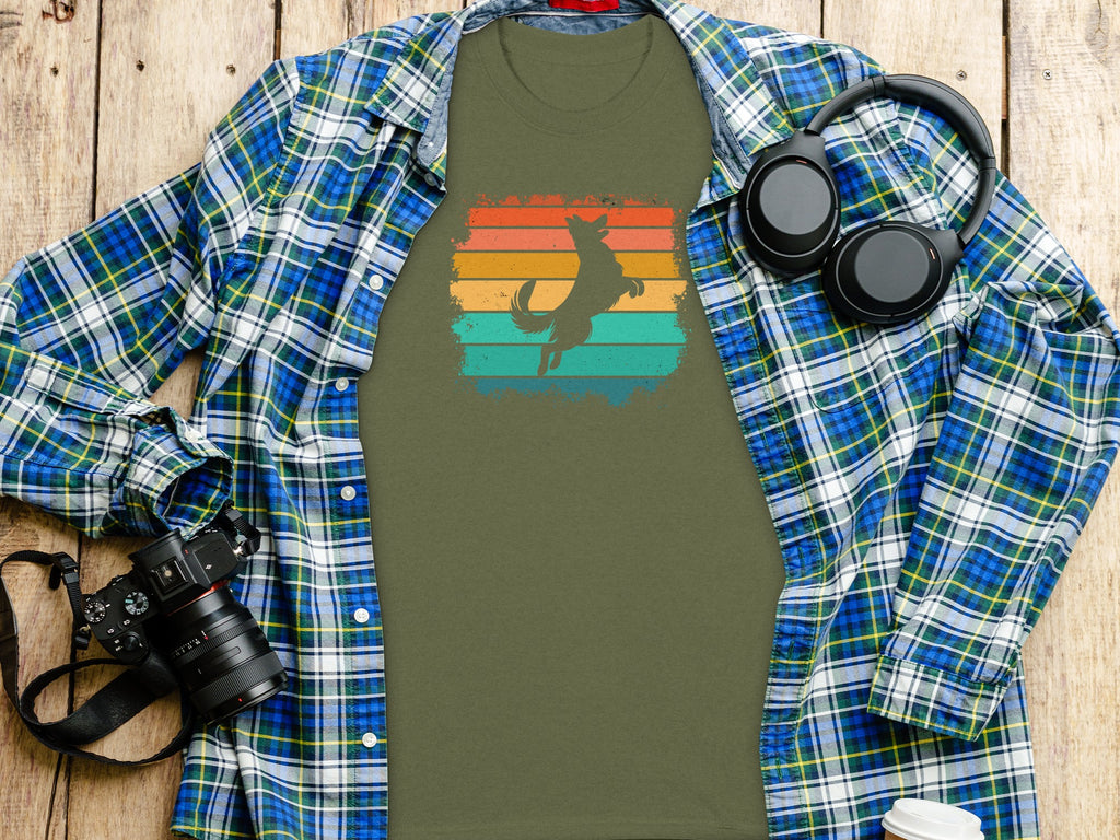 Green t-shirt with jumping dog graphic over colored retro stripes.